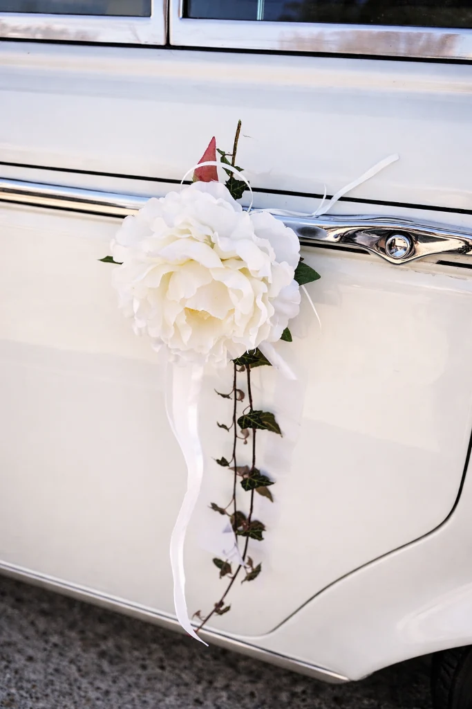 Weiße Pfingstrose mit Efeu und Satinband als Türdekoration am Rolls Royce